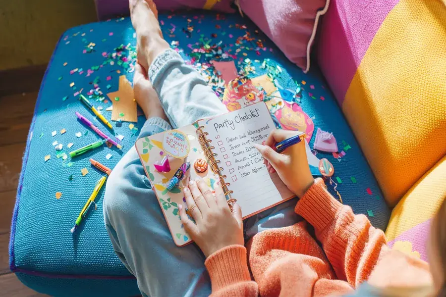 “Planung einer Geburtstagsparty mit Notizbuch und Checkliste”